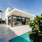 real estate investment white and grey concrete building near swimming pool under clear sky during daytime