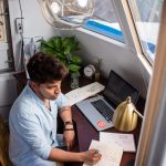 remote working man sits while writing in front of MacBook