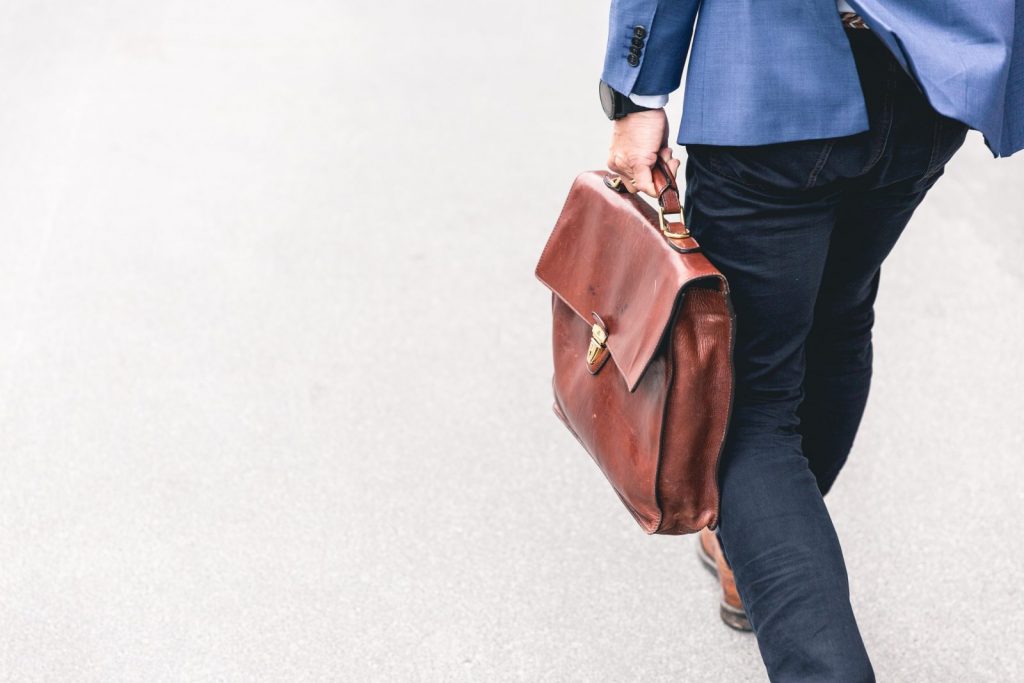 Temporary Work person walking holding brown leather bag