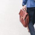 Temporary Work person walking holding brown leather bag