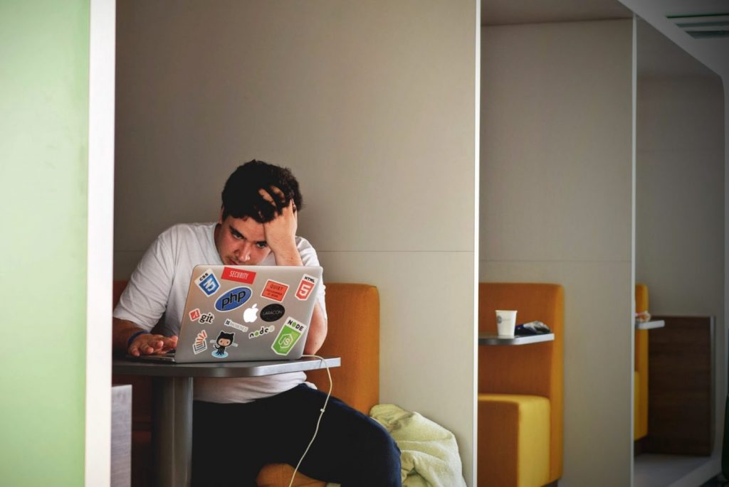 mental health man wearing white top using MacBook