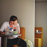 mental health man wearing white top using MacBook