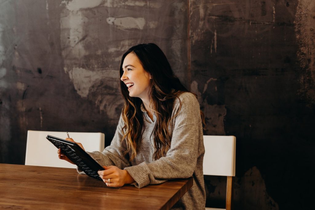 PR specialist woman sitting around table holding tablet