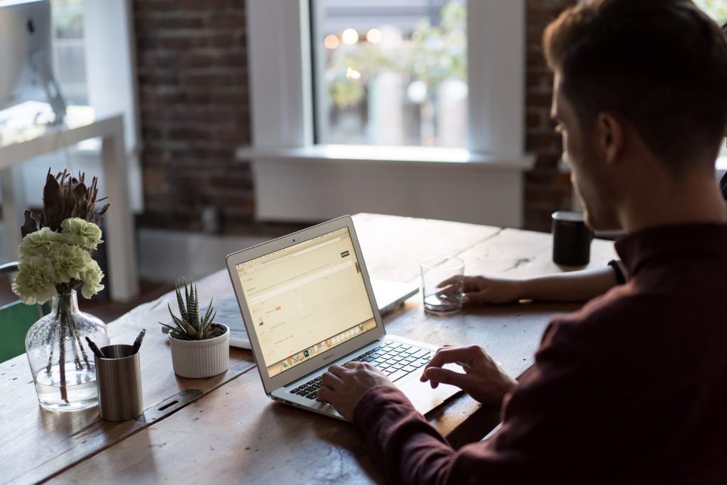 Vue.js Developer man operating laptop on top of table