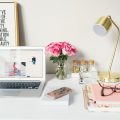 love business MacBook Air beside gold-colored study lamp and spiral books
