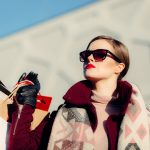 shallow focus photography of woman holding shopping bags during day