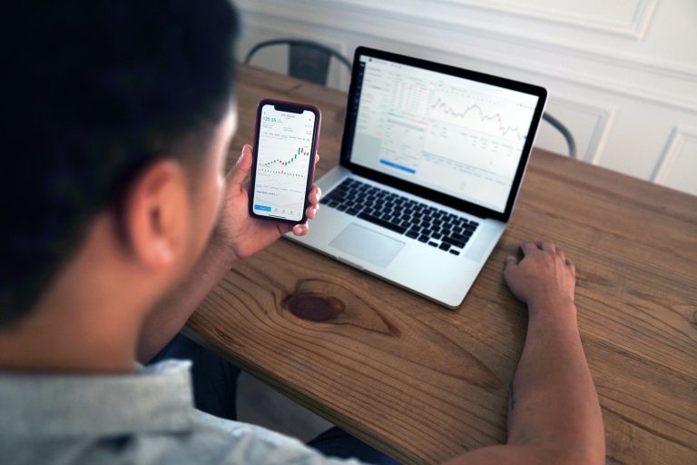 person holding iphone 6 near macbook pro