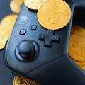 a video game controller surrounded by bitcoins