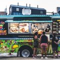 a group of people standing in front of a food truck