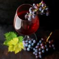 red grapes on clear glass wine