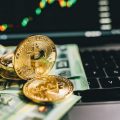 Close-up Shot of Gold Coins and Paper Money on the Keyboard of a Laptop