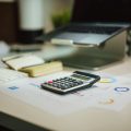 a calculator sitting on top of a table next to a laptop