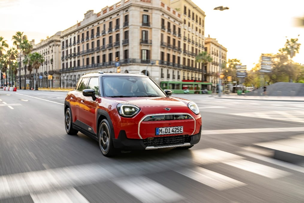 a red car driving down street