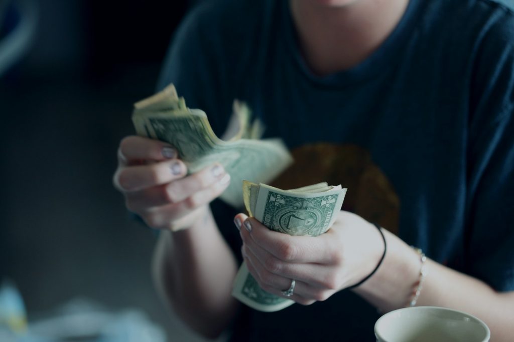 emergency fund -focus photography of person counting dollar banknotes