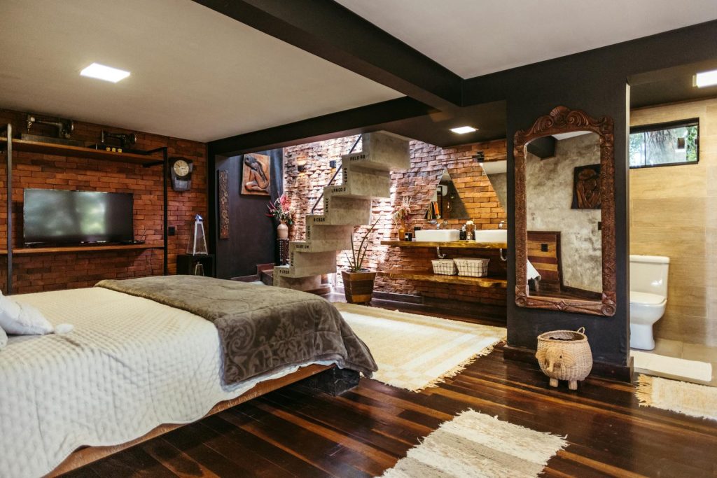 Cozy bedroom featuring exposed brick walls, wooden accents, and a stylish rustic design.