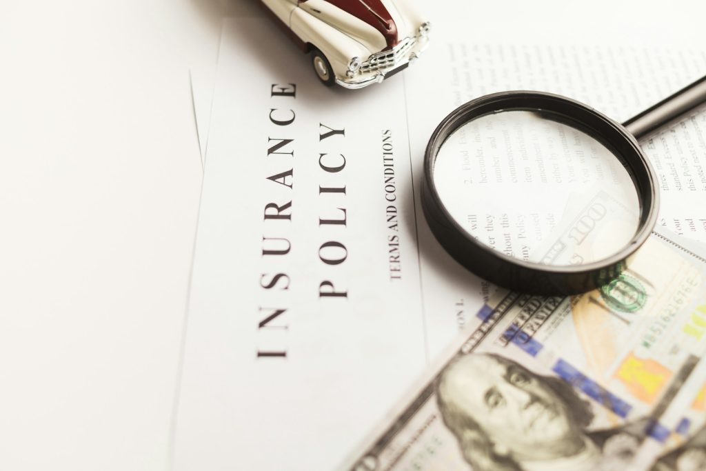 Types of Car Insurance Policies- a magnifying glass sitting on top of a piece of paper