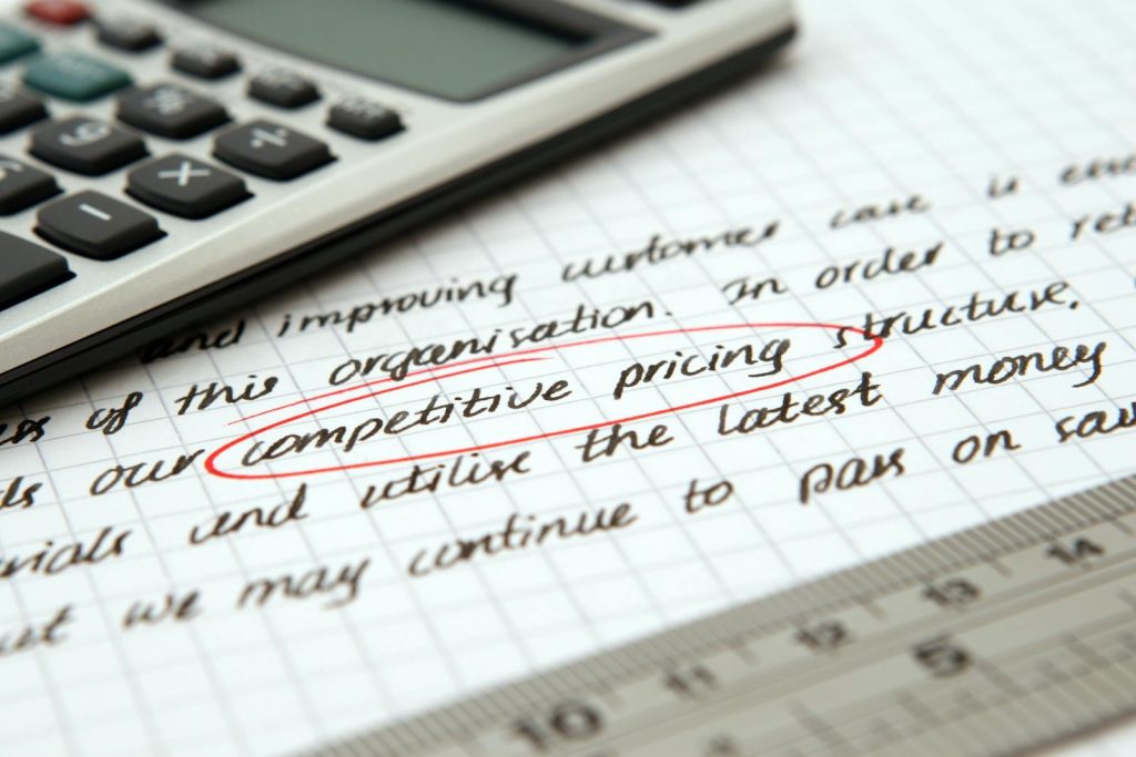 Pricing Analysis- Focused image of handwritten business notes with calculator emphasizing pricing strategy.