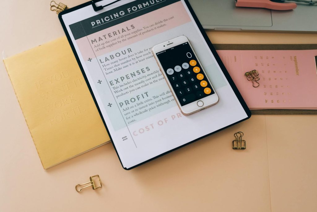 Pricing- Organized business tools with a smartphone, documents, and stationery in a flat lay format.