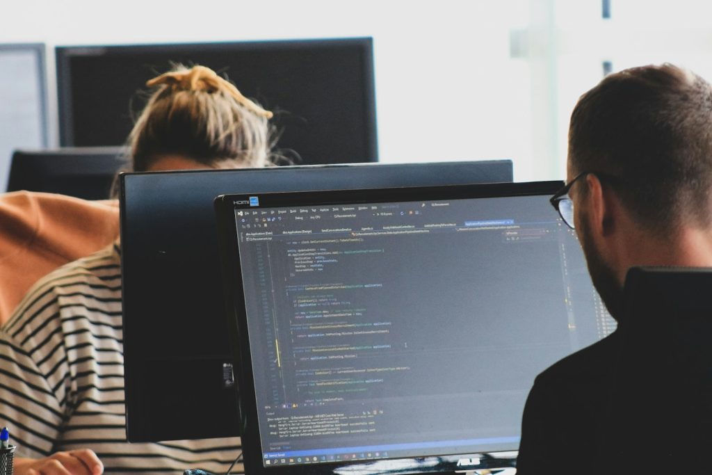 Advanced Computing- woman in black shirt sitting beside black flat screen computer monitor