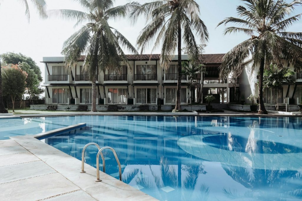 Hotel Booking Tips- green palm trees and pool