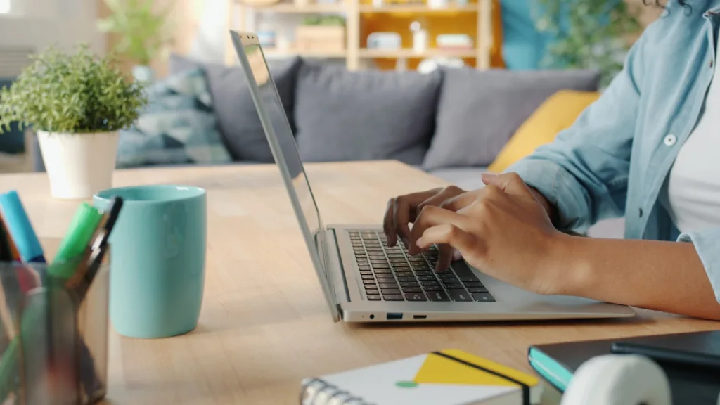 Freelance Career- Person typing on a laptop at a wooden desk.