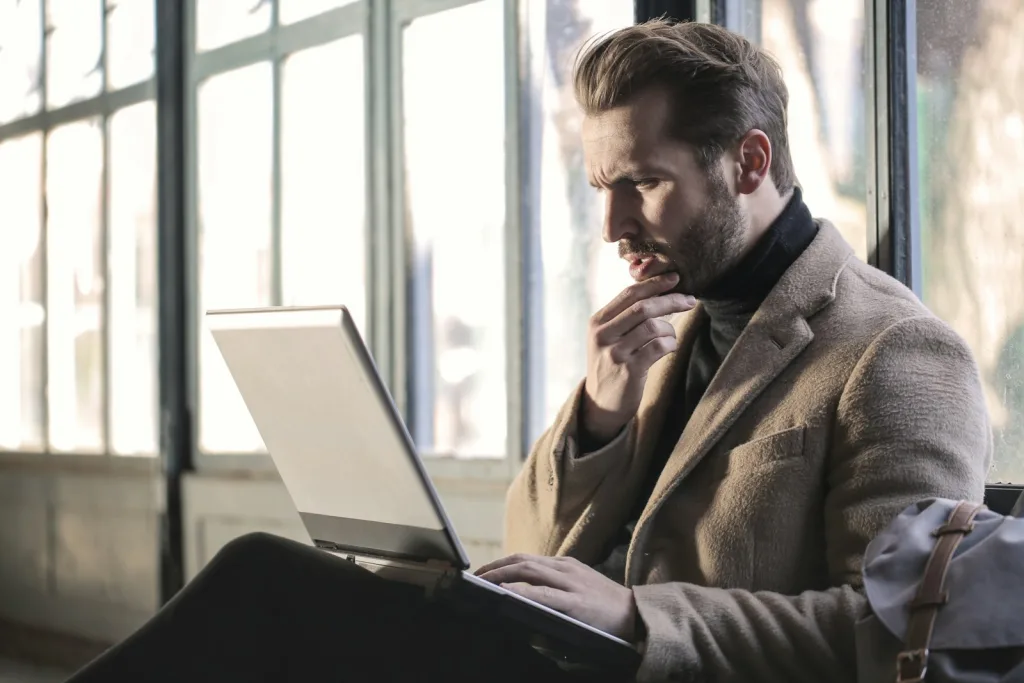Common Pitfalls Business Owners Should Avoid 1 man holding his chin facing laptop computer